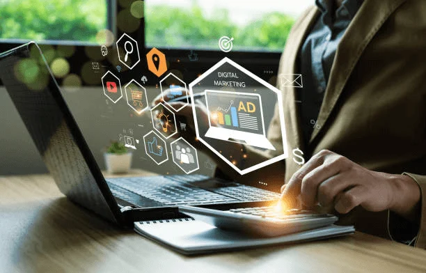Photo of a person using a laptop with digital marketing and advertising icons